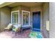 Cozy front porch with chairs, bench, and a blue front door adorned with a wreath at 13609 Messina Loop # 104, Bradenton, FL 34211