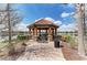 Charming lakeside gazebo with stone accents and tiled roof, offering a peaceful retreat with serene water views at 13609 Messina Loop # 104, Bradenton, FL 34211