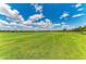 Expansive golf course view with lush green grass and a blue sky dotted with fluffy clouds at 13609 Messina Loop # 104, Bradenton, FL 34211