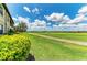 A lush green golf course with a walking path meanders past homes under a clear blue sky with fluffy clouds at 13609 Messina Loop # 104, Bradenton, FL 34211