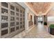 Hallway with wine storage, brick ceiling, decorative tiling and elegant light fixtures at 13609 Messina Loop # 104, Bradenton, FL 34211