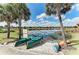 Community kayak launch featuring two kayaks on a sandy beach with picturesque lake and palm tree views at 13609 Messina Loop # 104, Bradenton, FL 34211