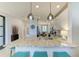 Kitchen featuring a granite countertop breakfast bar, modern lighting, white cabinets, and stainless steel appliances at 13609 Messina Loop # 104, Bradenton, FL 34211