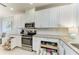 Bright kitchen featuring white cabinets, granite countertops, stainless steel appliances, and under-cabinet storage at 13609 Messina Loop # 104, Bradenton, FL 34211