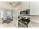 Modern kitchen featuring stainless steel appliances, granite countertops, and a view into the adjacent breakfast nook at 13609 Messina Loop # 104, Bradenton, FL 34211
