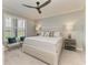 Spacious primary bedroom offers natural light, large bed, ceiling fan, and serene golf course views at 13609 Messina Loop # 104, Bradenton, FL 34211