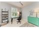 Bright office showcasing a glass desk, shelves, and a green dresser, accentuated by a modern black-and-white rug at 13609 Messina Loop # 104, Bradenton, FL 34211