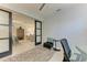 Office interior featuring a glass desk and black chair; a sleek slider door reveals an adjacent sitting room at 13609 Messina Loop # 104, Bradenton, FL 34211