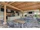 Covered patio area with fireplace, bar area, stone columns, and outdoor seating at 13609 Messina Loop # 104, Bradenton, FL 34211