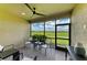 Covered patio with comfortable seating overlooking a lush golf course on a sunny day at 13609 Messina Loop # 104, Bradenton, FL 34211