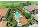 Community pool with orange lounge chairs surrounded by lush landscaping and lawns at 13609 Messina Loop # 104, Bradenton, FL 34211