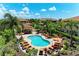 Beautiful pool area with palm trees, lounge chairs, umbrellas and resort-style amenities at 13609 Messina Loop # 104, Bradenton, FL 34211
