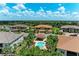 Aerial view of a community pool area with palm trees, lounge chairs, and umbrellas at 13609 Messina Loop # 104, Bradenton, FL 34211