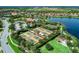 Aerial view of tennis courts, playground, pool and clubhouse located in a luxurious gated community near a lake at 13609 Messina Loop # 104, Bradenton, FL 34211