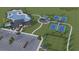 Aerial view showcasing the community pool, tennis courts, playground, clubhouse, and parking area at 13871 Heartwood Way, Parrish, FL 34219