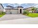 Stunning two-story home featuring a three-car garage, paver driveway, and beautifully landscaped front yard at 13871 Heartwood Way, Parrish, FL 34219