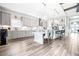 Open-concept kitchen and dining area featuring gray cabinetry, stainless steel appliances, and a large kitchen island at 13871 Heartwood Way, Parrish, FL 34219