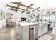 Bright open kitchen features stainless appliances, center island, and wood beam ceiling at 13871 Heartwood Way, Parrish, FL 34219