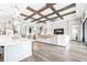 Spacious open-concept living room with hardwood floors, wood beam ceiling, and stylish decor at 13871 Heartwood Way, Parrish, FL 34219
