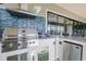 Stainless steel outdoor grill with a tile backsplash, sink, and bar seating perfect for entertaining at 13871 Heartwood Way, Parrish, FL 34219