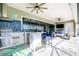 Covered outdoor kitchen with stainless steel grill, tile backsplash, bar seating, and a relaxing seating area at 13871 Heartwood Way, Parrish, FL 34219