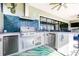 Outdoor kitchen with granite countertops, stainless steel grill, bar seating, and tile backsplash at 13871 Heartwood Way, Parrish, FL 34219