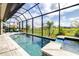 Resort-style pool with screened-in enclosure and a breathtaking view of the lush green backyard at 13871 Heartwood Way, Parrish, FL 34219