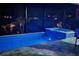 Night view of a lit screened-in swimming pool with a spa and stone tile surround at 13871 Heartwood Way, Parrish, FL 34219