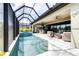 Screened-in swimming pool with a spa, stone tile surround, and plenty of space for lounging and entertaining at 13871 Heartwood Way, Parrish, FL 34219