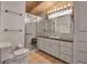 Bright bathroom features glass shower, white cabinets and tile floors at 1808 Coquina Dr, Sarasota, FL 34231
