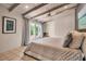 Bright bedroom with white ceiling beams, neutral decor and natural light from large windows at 1808 Coquina Dr, Sarasota, FL 34231