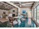 An open-concept dining area with a glass-top table, vaulted ceiling, and view of the living area at 1808 Coquina Dr, Sarasota, FL 34231