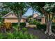 Beautiful home with a well-manicured front yard featuring mature trees, shrubs, and a charming walkway at 1808 Coquina Dr, Sarasota, FL 34231
