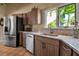 Stylish kitchen featuring stainless appliances, wood cabinets, granite countertops and a garden view at 1808 Coquina Dr, Sarasota, FL 34231