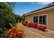 Charming walkway lined with vibrant red flowers and lush greenery leads to the side of the home at 1808 Coquina Dr, Sarasota, FL 34231