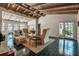 Spacious living room with vaulted wood beam ceiling, accent chairs, a fireplace, and glass doors to the outside at 1808 Coquina Dr, Sarasota, FL 34231