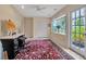 Well-lit living room with bay window, workspace, neutral walls and vintage rug at 1808 Coquina Dr, Sarasota, FL 34231