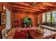 Warm living room with wood paneling, beamed ceiling, tile floors and a large decorative rug at 1808 Coquina Dr, Sarasota, FL 34231