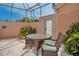 A quaint outdoor patio set with woven chairs and a glass-topped table, surrounded by lush tropical plants at 1808 Coquina Dr, Sarasota, FL 34231
