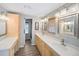 Bathroom with double sinks, wood-look floors, framed mirrors, and white cabinets for a clean and modern design at 2107 Palma Sola Blvd # 7, Bradenton, FL 34209