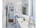 Bright bathroom with double sink vanity, marble floors, and a framed mirror for a clean, modern design at 2107 Palma Sola Blvd # 7, Bradenton, FL 34209