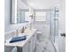 Bright bathroom with white marble floors, glass shower, and modern vanity with a large mirror and a towel at 2107 Palma Sola Blvd # 7, Bradenton, FL 34209