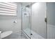 Updated bathroom featuring a tiled shower, glass door, and modern fixtures at 2107 Palma Sola Blvd # 7, Bradenton, FL 34209