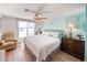 Comfortable bedroom with ceiling fan features wood-look floors, a cozy chair, and bright, coastal-themed decor for a relaxing retreat at 2107 Palma Sola Blvd # 7, Bradenton, FL 34209
