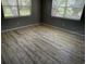 Bright bedroom featuring plank floors, neutral walls, two windows with blinds and an adjacent bathroom at 2311 W 52Nd Ave Drive, Bradenton, FL 34207