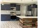 Modern kitchen with stainless steel appliances, dark cabinets, subway tile backsplash, and island seating at 2311 W 52Nd Ave Drive, Bradenton, FL 34207