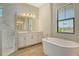 Bathroom featuring a soaking tub, glass shower, white cabinets and wood-look tile floors at 2469 Paradise Plum Dr, Sarasota, FL 34240
