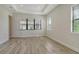 Bedroom with tray ceiling, wood-look tile floors and three windows at 2469 Paradise Plum Dr, Sarasota, FL 34240