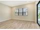 Bright bedroom with large window, tile floors, and sliding glass doors to outdoor patio at 2469 Paradise Plum Dr, Sarasota, FL 34240