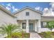 Inviting front entrance of a modern home with stone accents and a teal-colored door at 2469 Paradise Plum Dr, Sarasota, FL 34240